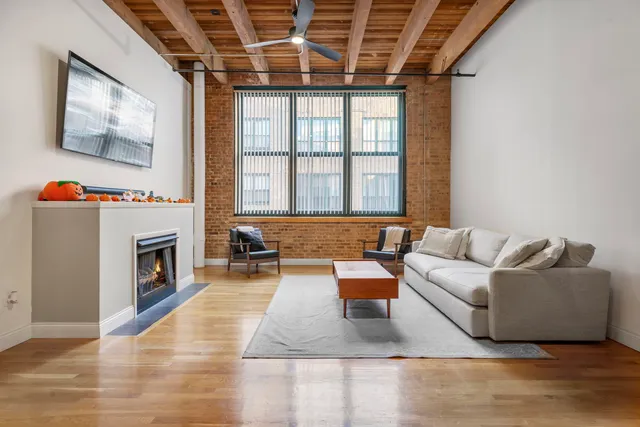 a living room with furniture a fireplace and a large window