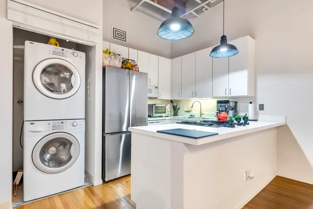 a kitchen with stainless steel appliances granite countertop a sink a stove a refrigerator and cabinets