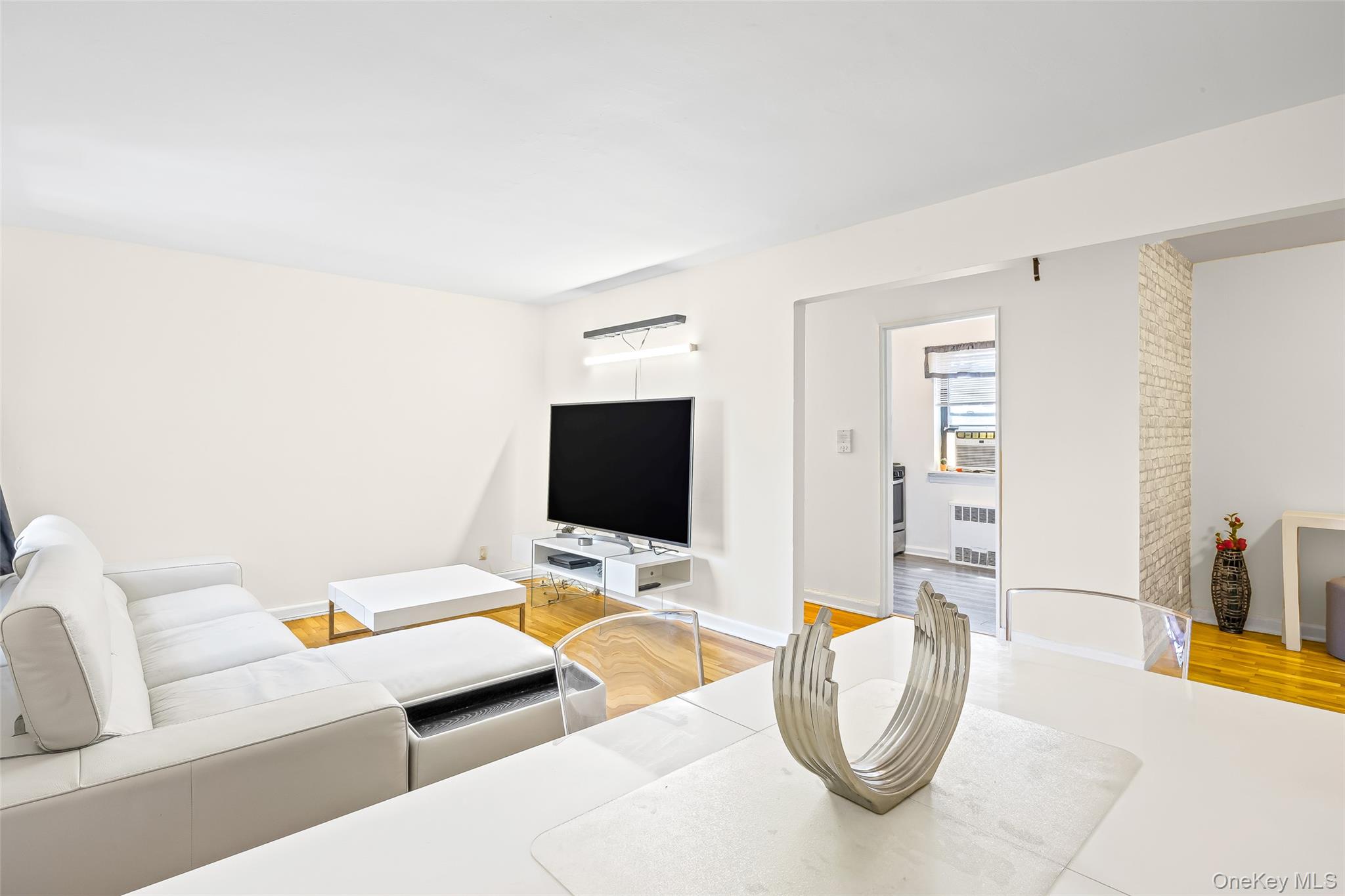 147-10 84th Road, Unit 4G Queens, NY 11435 - Photo 2 of 13 Living area with light wood finished floors and radiator heating unit