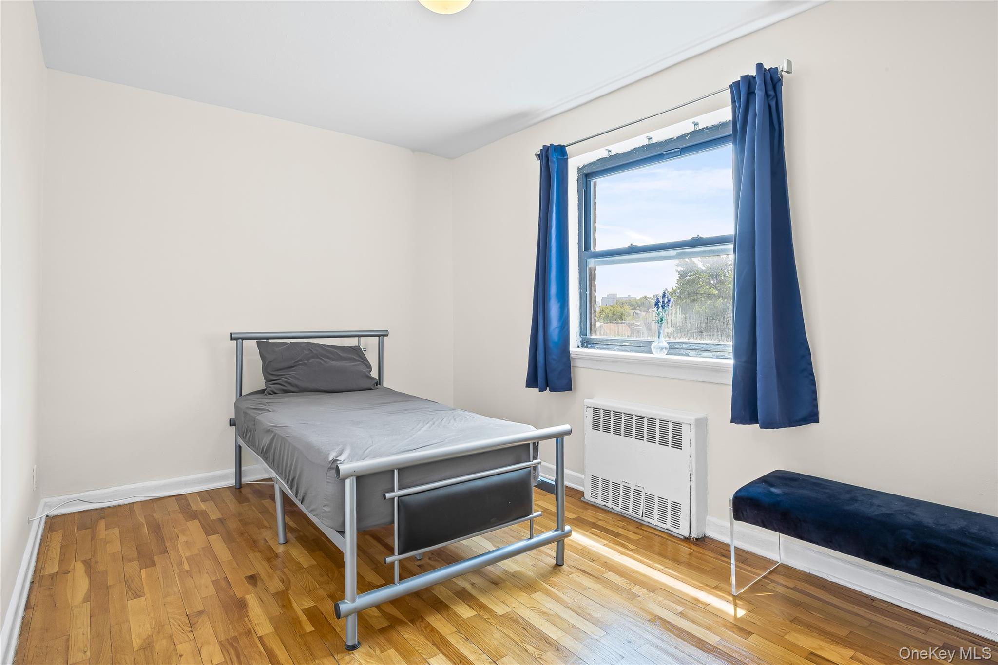 147-10 84th Road, Unit 4G Queens, NY 11435 - Photo 10 of 13 Bedroom featuring wood finished floors and radiator heating unit