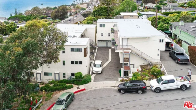 an aerial view of a house with a garden and parking space