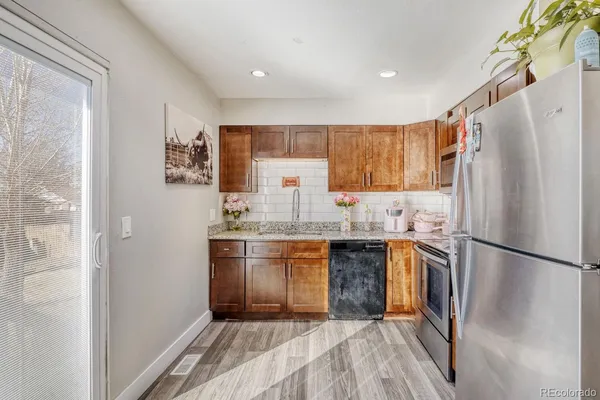 a kitchen with stainless steel appliances granite countertop a refrigerator sink and stove