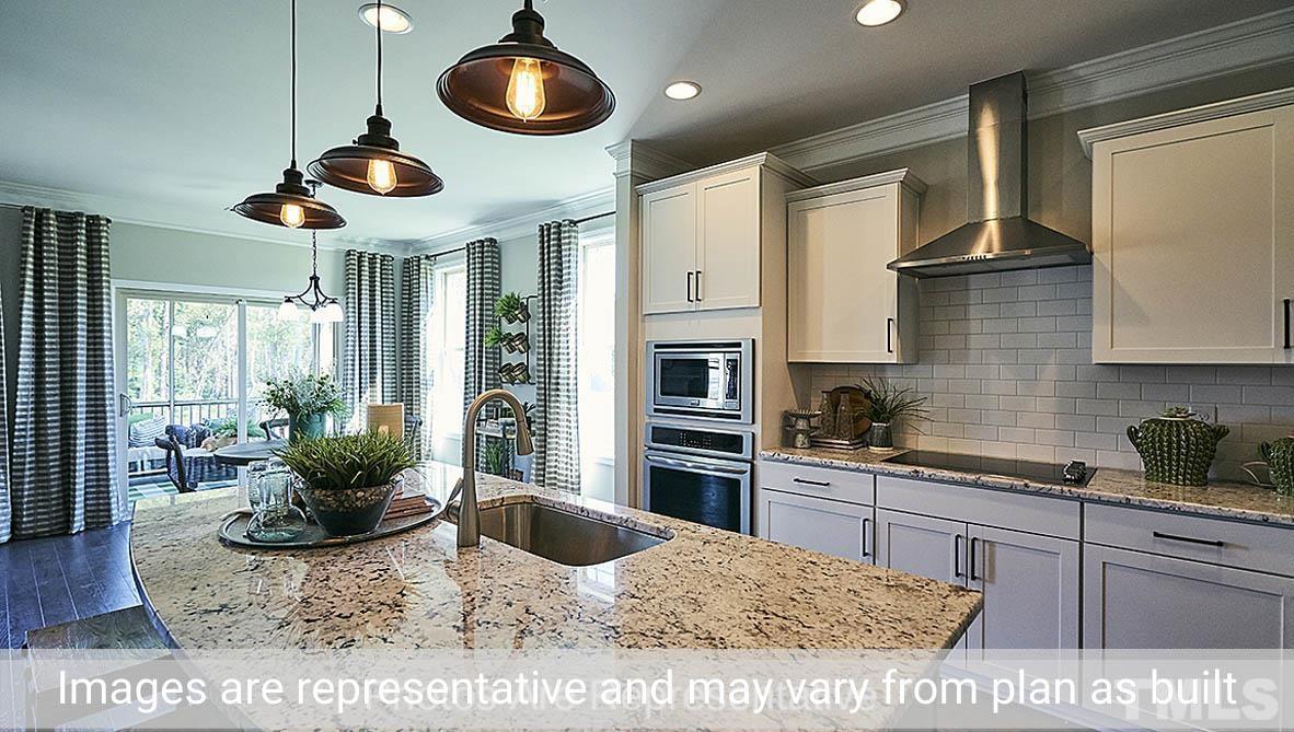 7704 Calcutta Drive Willow Spring, NC 27592 - Photo 11 of 30 a kitchen with stainless steel appliances granite countertop a stove a sink and a microwave