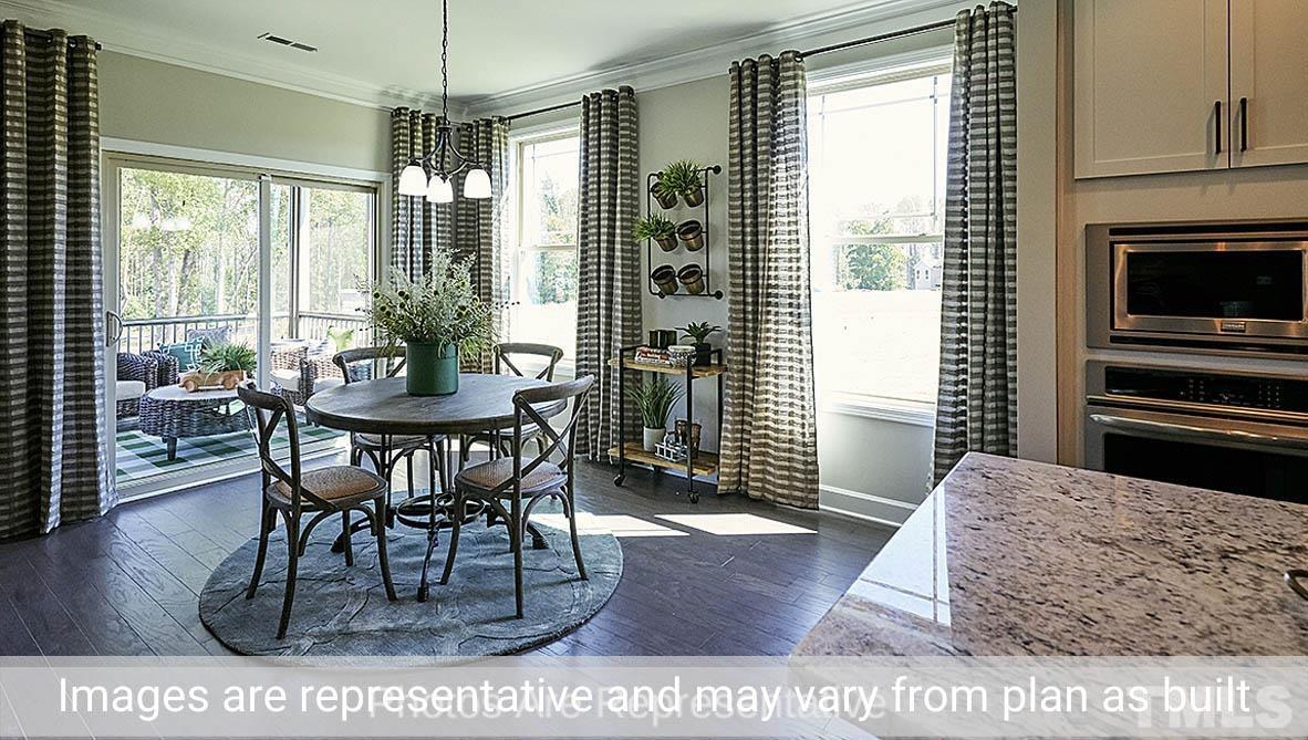 7704 Calcutta Drive Willow Spring, NC 27592 - Photo 12 of 30 a dining room with furniture a chandelier and wooden floor