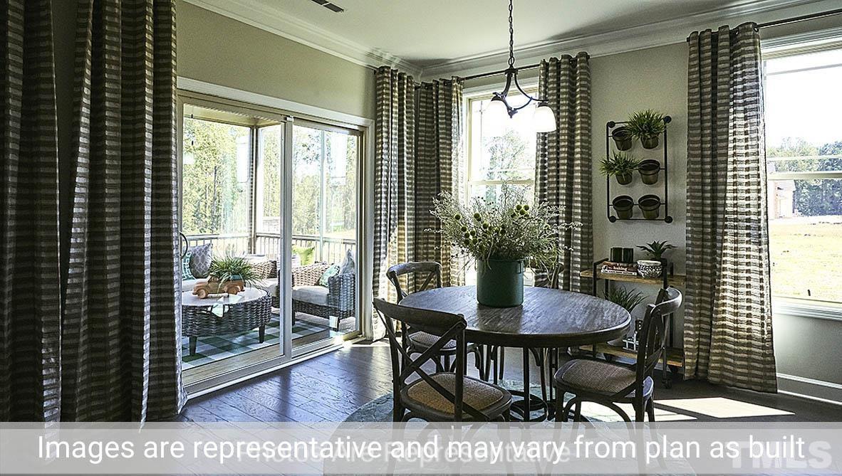 7704 Calcutta Drive Willow Spring, NC 27592 - Photo 13 of 30 a view of a dining room with furniture window and wooden floor