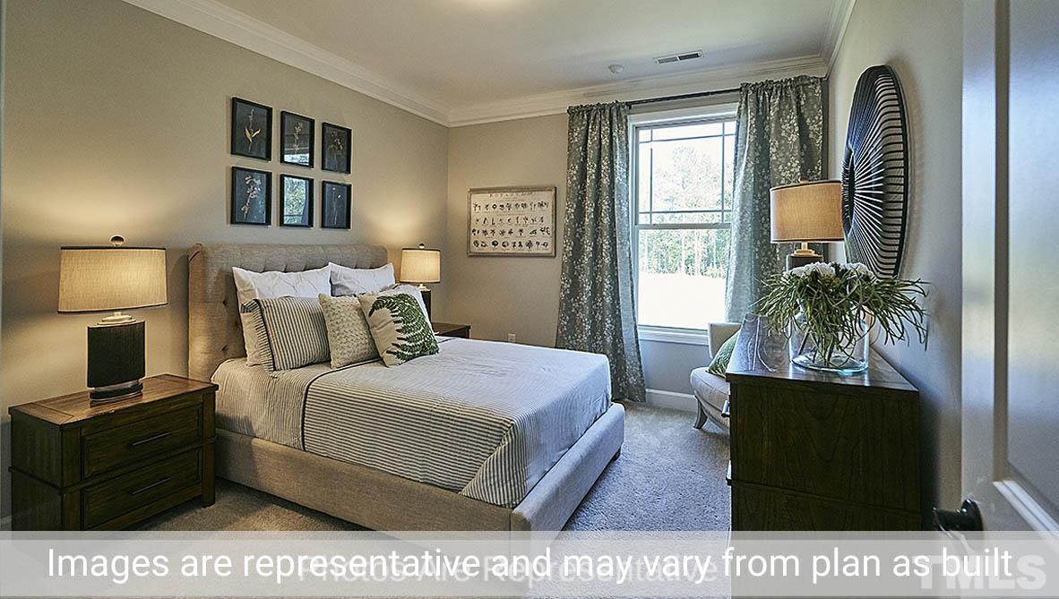 7704 Calcutta Drive Willow Spring, NC 27592 - Photo 16 of 30 a bedroom with a bed and a potted plant