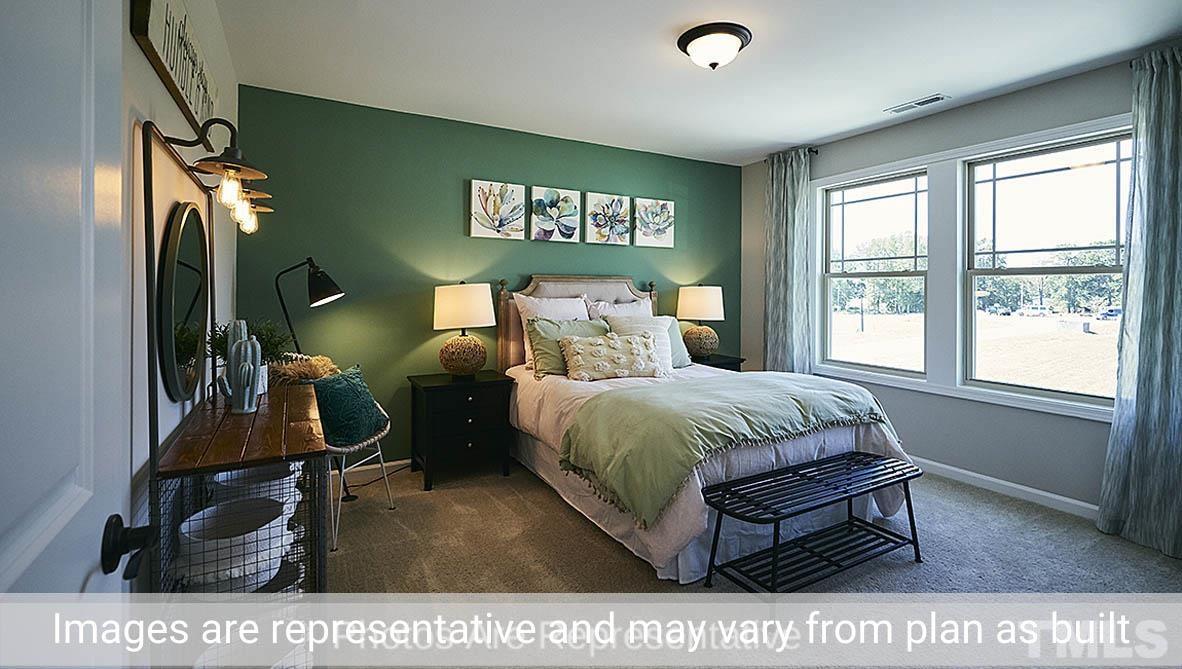 7704 Calcutta Drive Willow Spring, NC 27592 - Photo 22 of 30 a bedroom with a bed a dresser next to a window