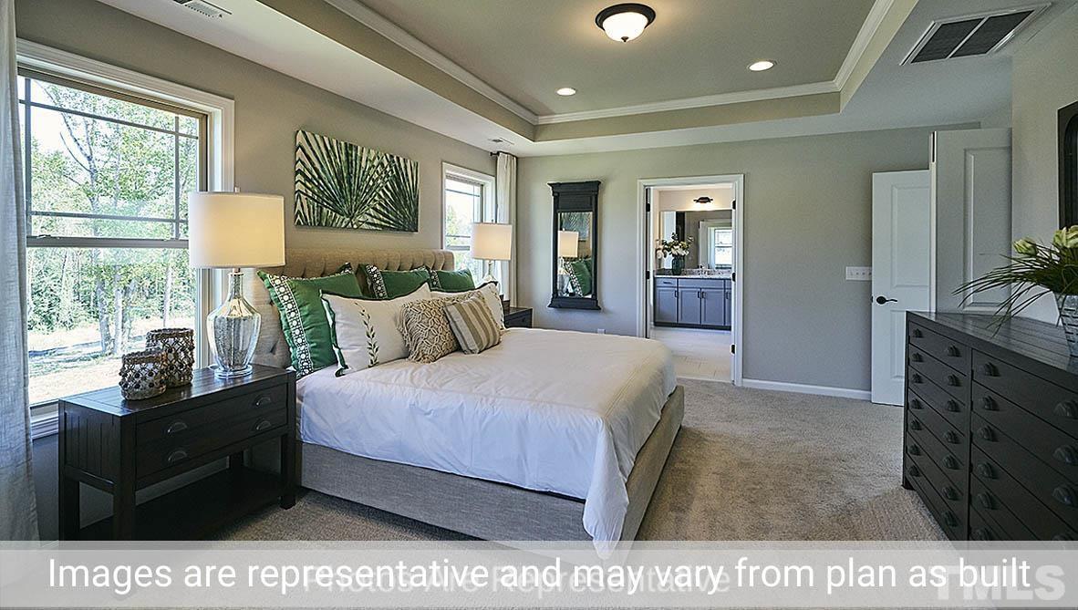 7704 Calcutta Drive Willow Spring, NC 27592 - Photo 23 of 30 a bed room with a bed window and mirror