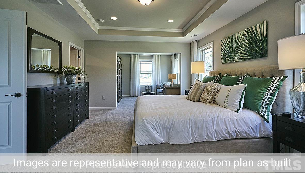 7704 Calcutta Drive Willow Spring, NC 27592 - Photo 24 of 30 a bedroom with a bed a mirror and windows