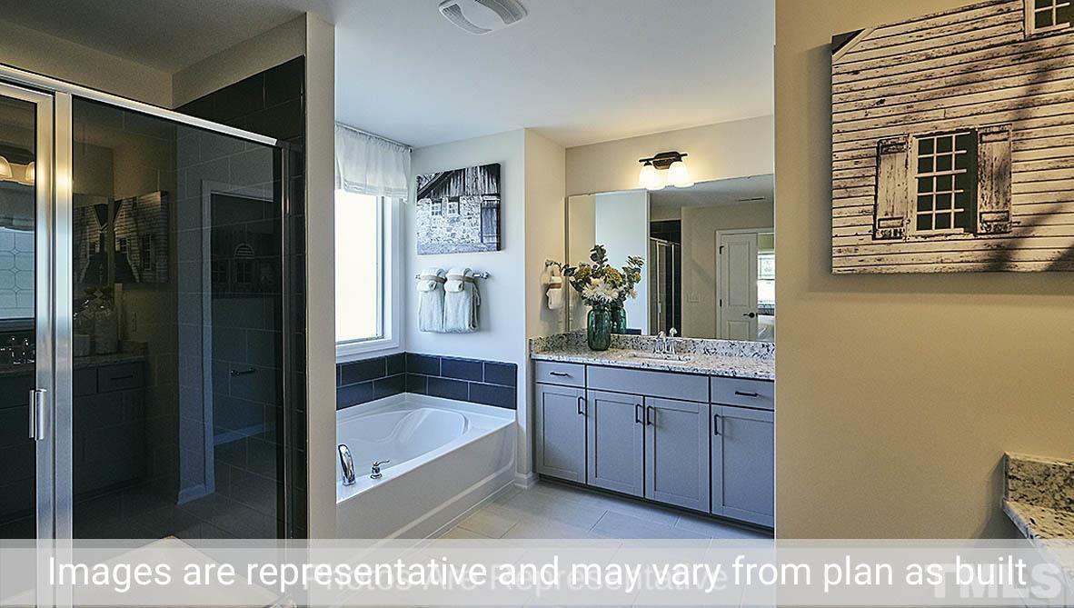 7704 Calcutta Drive Willow Spring, NC 27592 - Photo 27 of 30 a bathroom with a sink a mirror and a shower