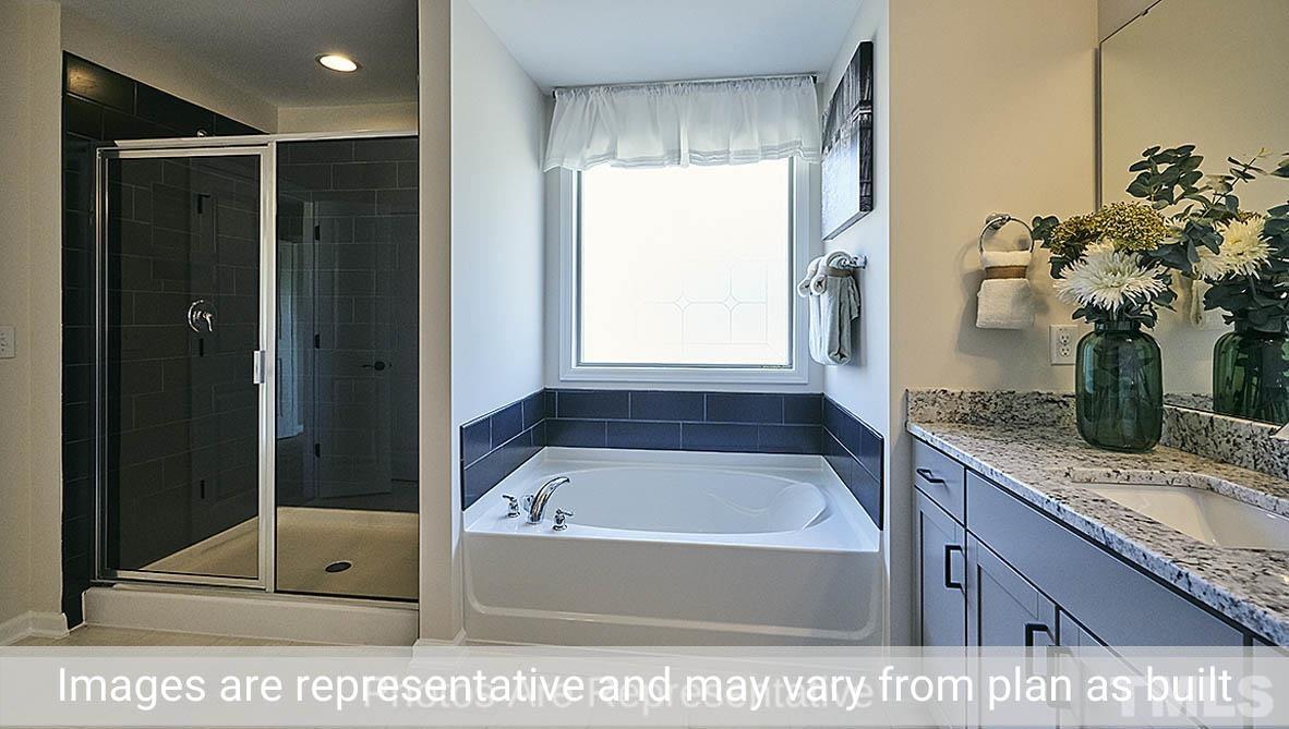 7704 Calcutta Drive Willow Spring, NC 27592 - Photo 28 of 30 a bathroom with a tub sink and mirror