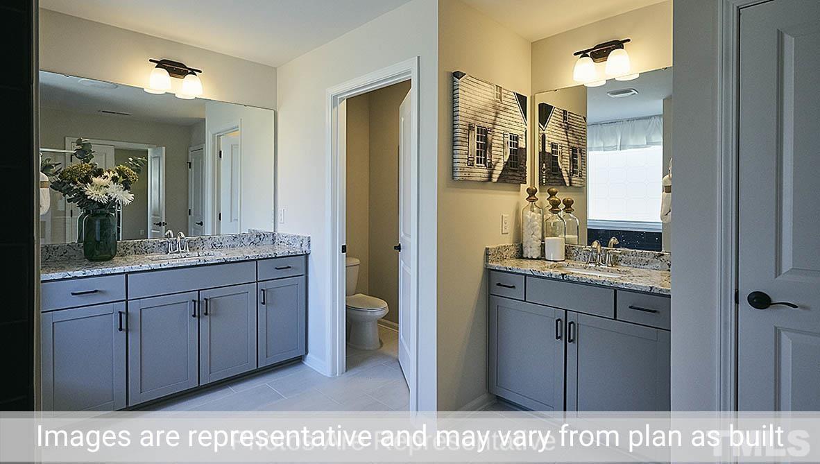 7704 Calcutta Drive Willow Spring, NC 27592 - Photo 30 of 30 a bathroom with a sink a mirror and a shower