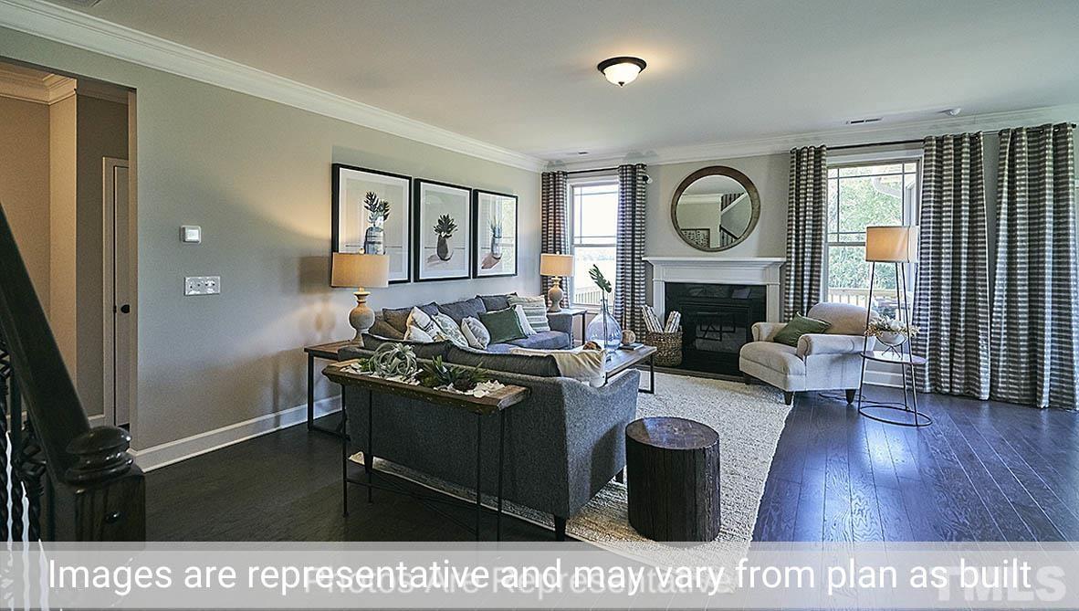 7704 Calcutta Drive Willow Spring, NC 27592 - Photo 6 of 30 a living room with furniture a fireplace and a large window
