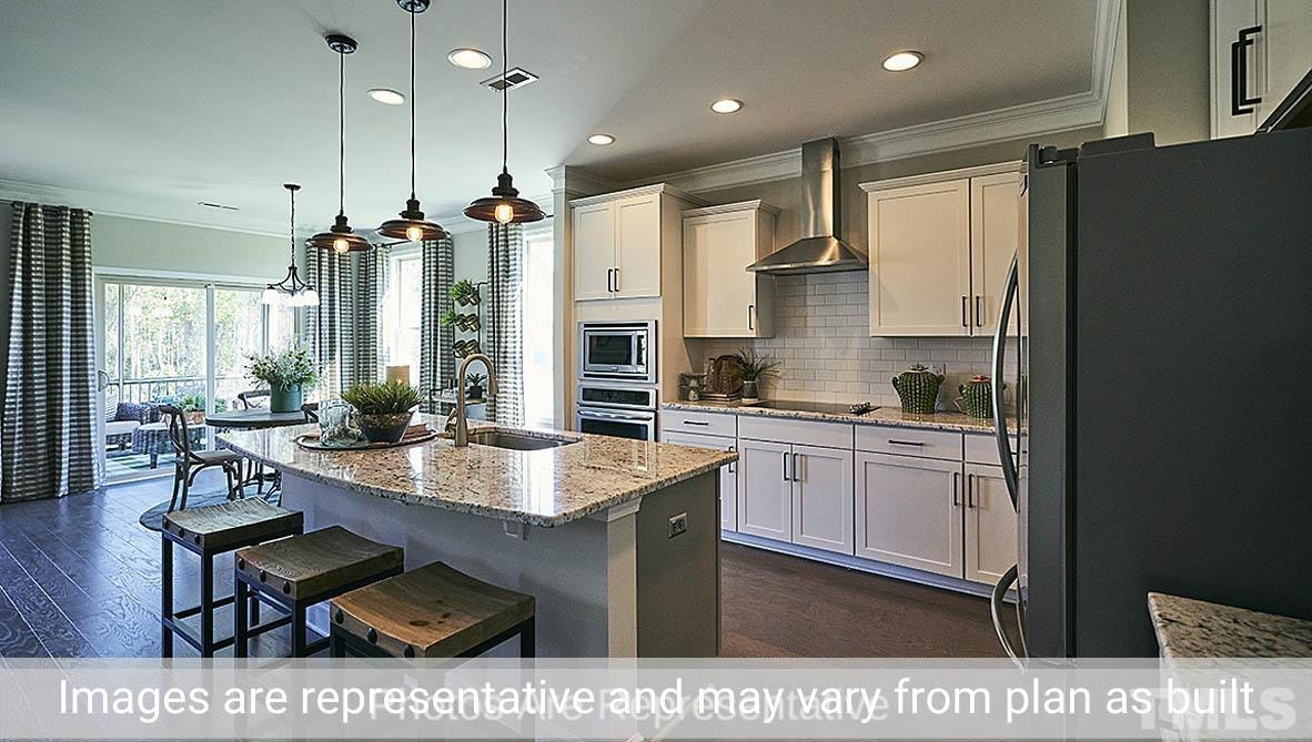 7704 Calcutta Drive Willow Spring, NC 27592 - Photo 10 of 30 a kitchen with stainless steel appliances kitchen island granite countertop a sink refrigerator and cabinets