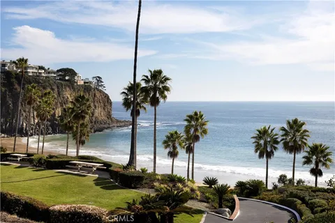 an aerial view of a city with lots of residential buildings and ocean view in back