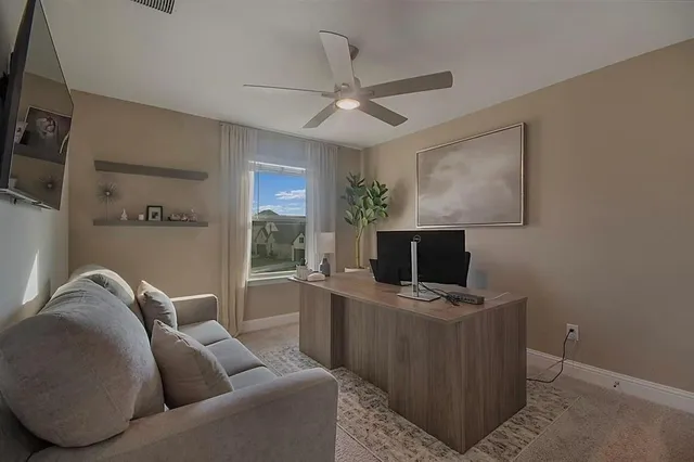 a living room with furniture a ceiling fan and a window