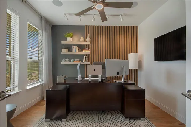 a living room with furniture a flat screen tv and kitchen view