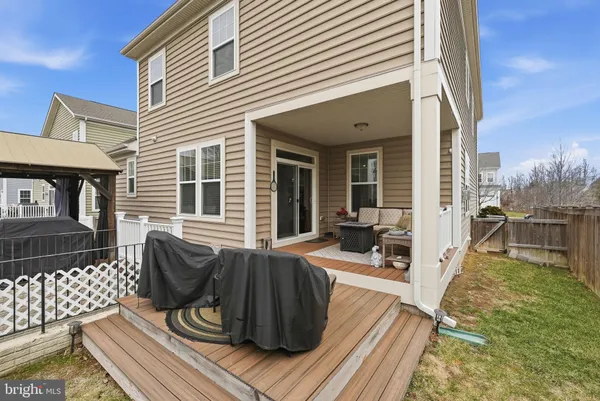 a view of a hallway with wooden floor and a living room