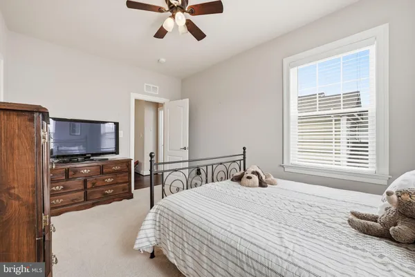 a spacious bedroom with a bed a couch and a chandelier