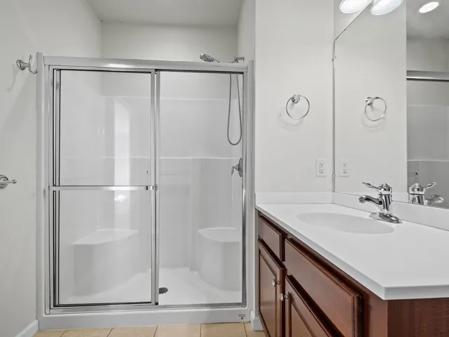 a bathroom with a shower sink and mirror