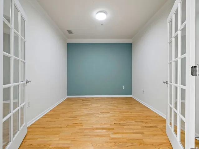 a view of a big room with wooden floor and windows