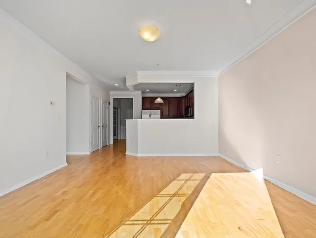 a view of a big room with wooden floor and windows