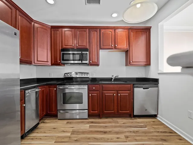 a kitchen with granite countertop a stove and a microwave oven