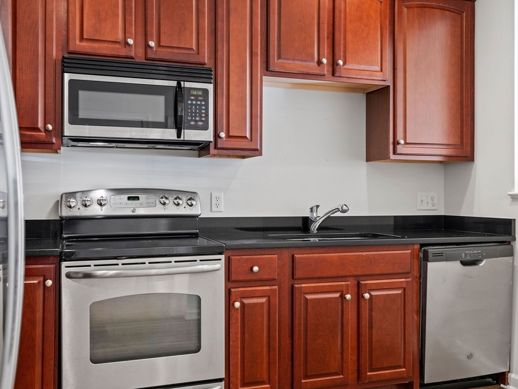 170 Clocktower Drive, Unit 5103 Waltham, MA 02452 - Photo 7 of 29 a kitchen with granite countertop cabinets stainless steel appliances and a sink