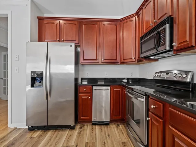 a kitchen with stainless steel appliances granite countertop a refrigerator and a stove top oven