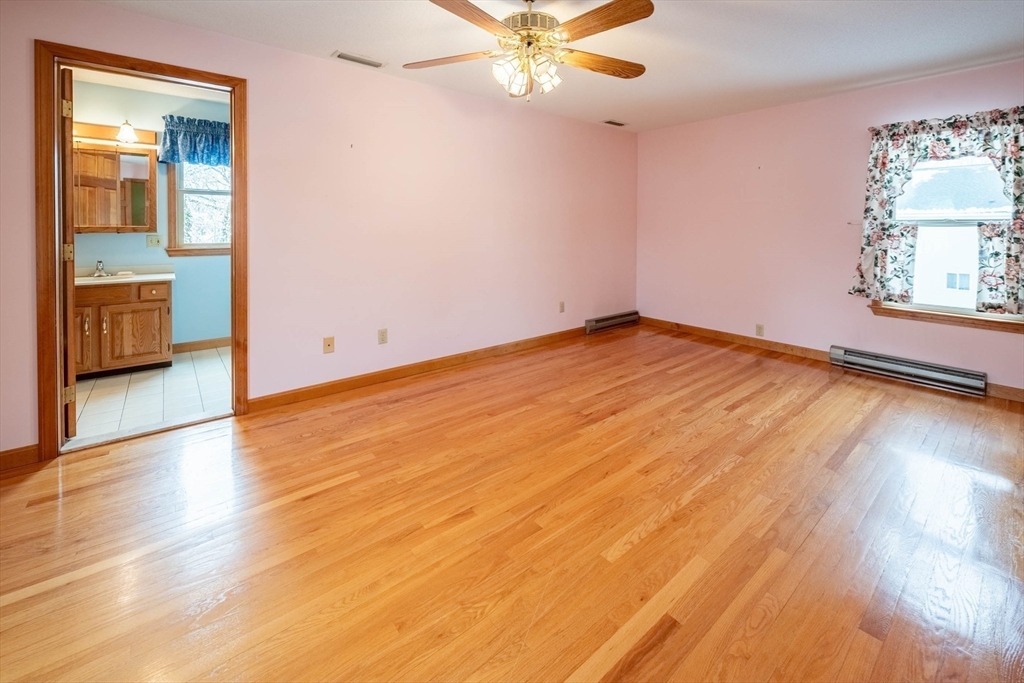 128 Ann Street Chicopee, MA 01020 - Photo 9 of 17 an empty room with wooden floor fan and windows