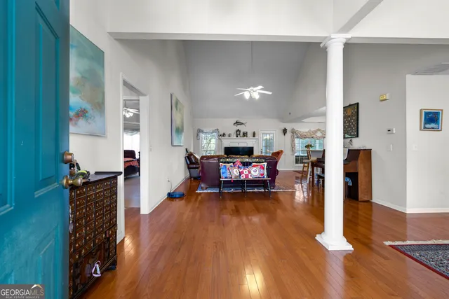 a dining room with furniture kitchen view and wooden floor