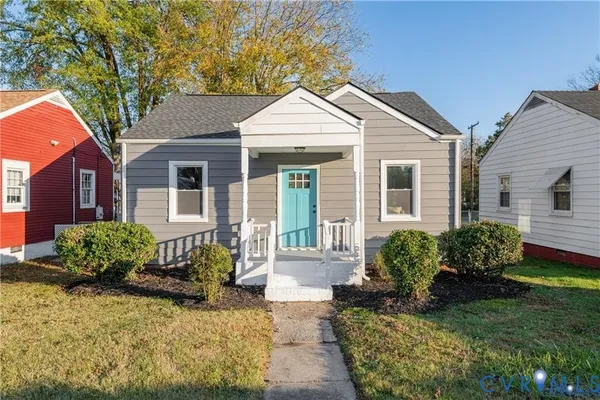 a front view of a house with a yard and potted plants