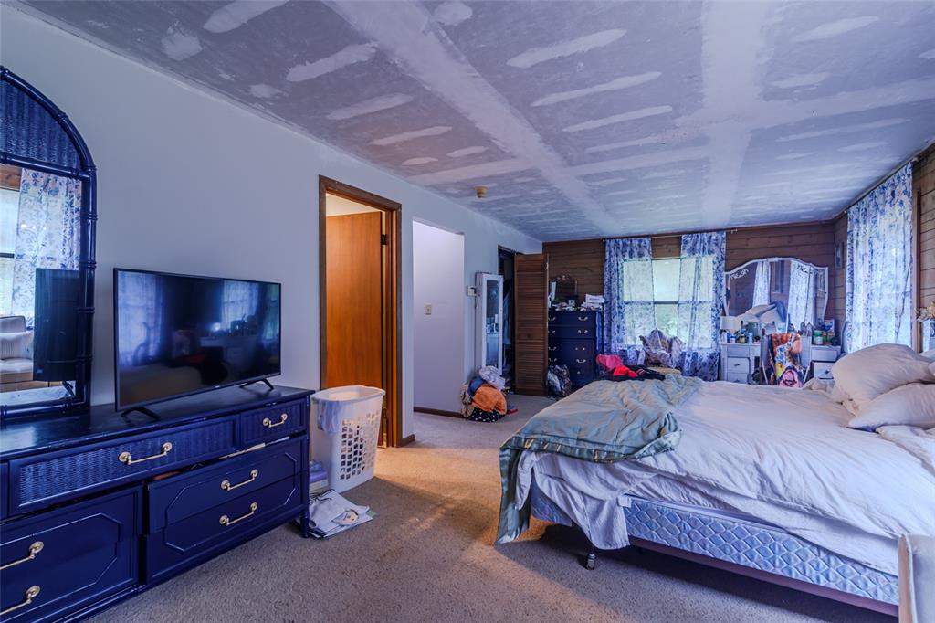 1600 Southwest 42nd Street Ocala, FL 34471 - Photo 32 of 57 a bedroom with a bed and flat screen tv