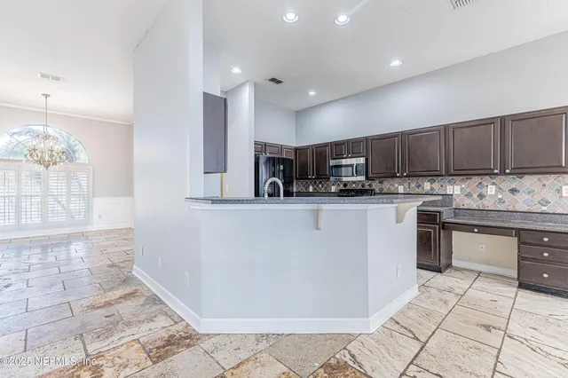 a kitchen with stainless steel appliances granite countertop a stove sink and cabinets