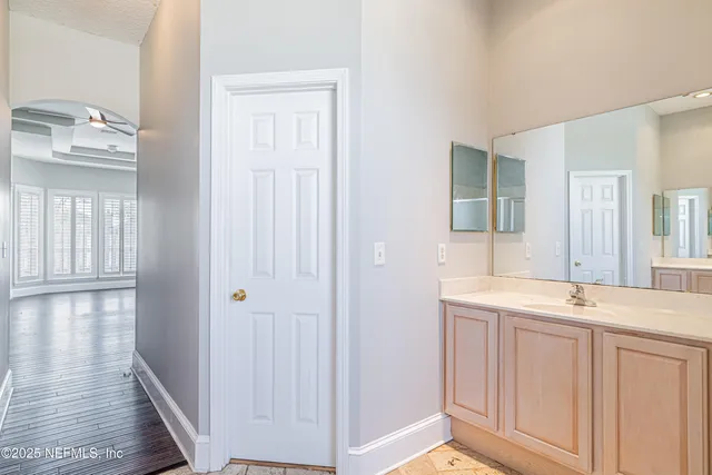 a spacious bathroom with a tub sink and mirror