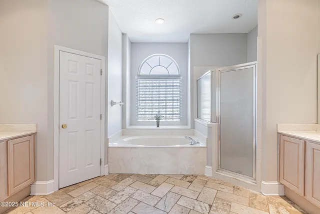 an empty room with a ceiling fan and windows