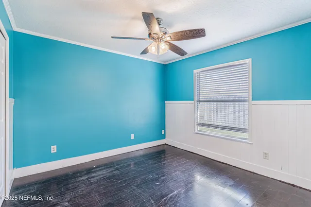 an empty room with a window and a fan