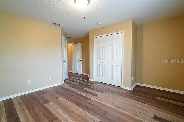a view of an empty room with wooden floor