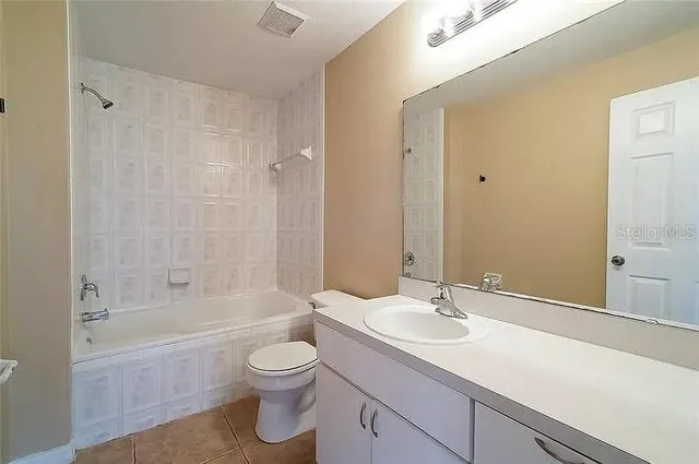 a bathroom with a granite countertop toilet a sink and a bathtub