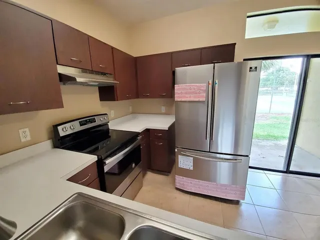 a kitchen with stainless steel appliances a refrigerator sink and cabinets