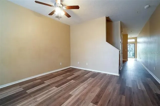 a view of empty room with wooden floor