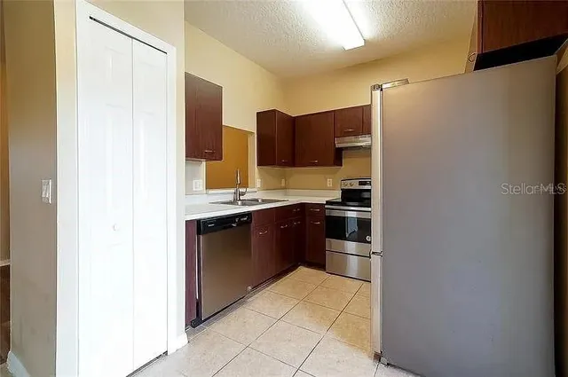 a kitchen with stainless steel appliances granite countertop a refrigerator and a stove