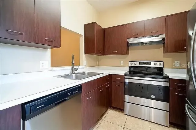 a kitchen with stainless steel appliances a stove a sink and a microwave