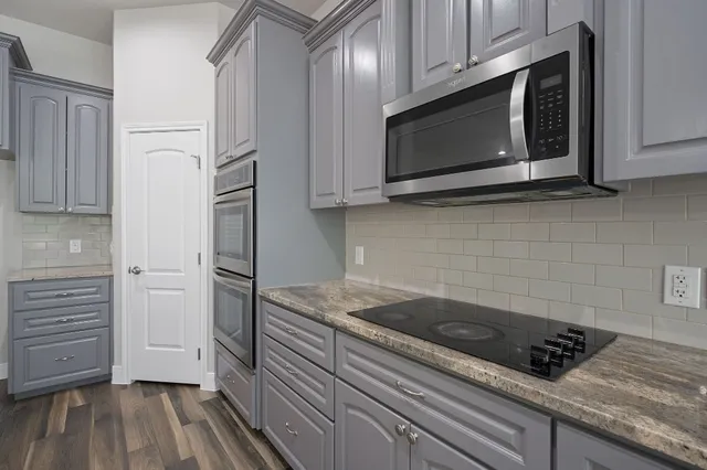 a kitchen with a sink cabinets and wooden floor