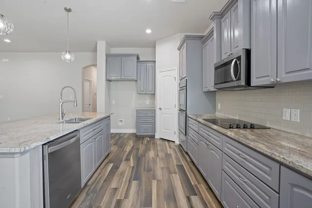 a kitchen with stainless steel appliances white cabinets and a stove top oven