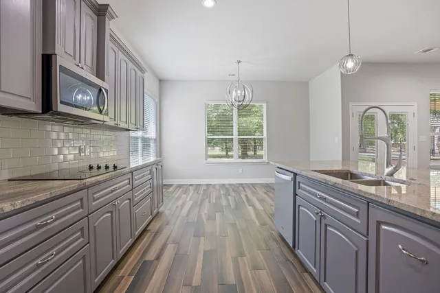 a kitchen with stainless steel appliances granite countertop a sink stove and refrigerator