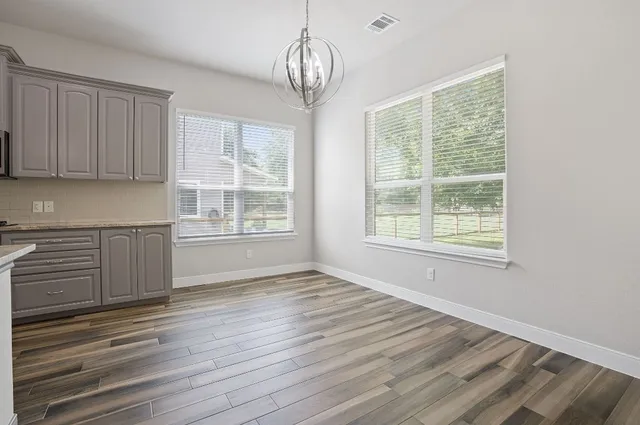 a kitchen with stainless steel appliances granite countertop a lot of counter space and wooden floors