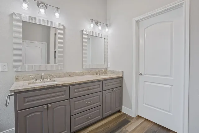 a bathroom with a granite countertop sink a toilet and shower