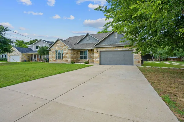 a front view of a house with a yard and trees