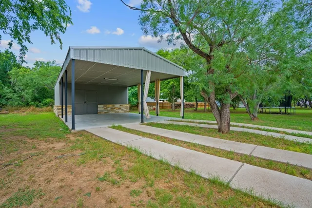 a view of a house with a yard and large tree